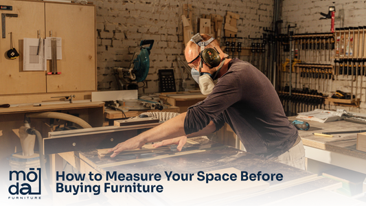 Person measuring room dimensions before buying furniture from Moda Home Furniture Houston