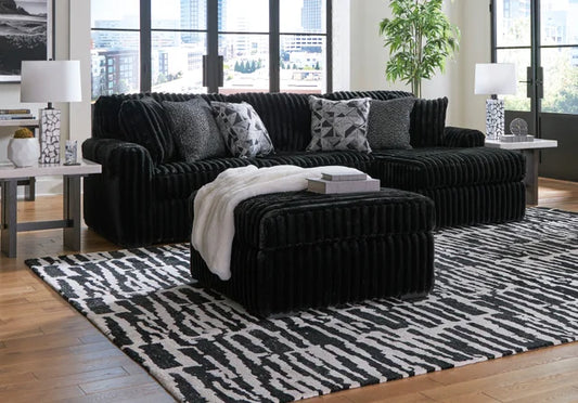 Ashley 981-03 2-piece black sectional with chaise and ottoman featuring reversible cushions and accent pillows from Moda Home Furniture